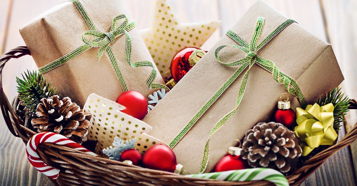 beautifully wrapped gifts in a basket of pine cones, candy canes, bows and ornaments. 