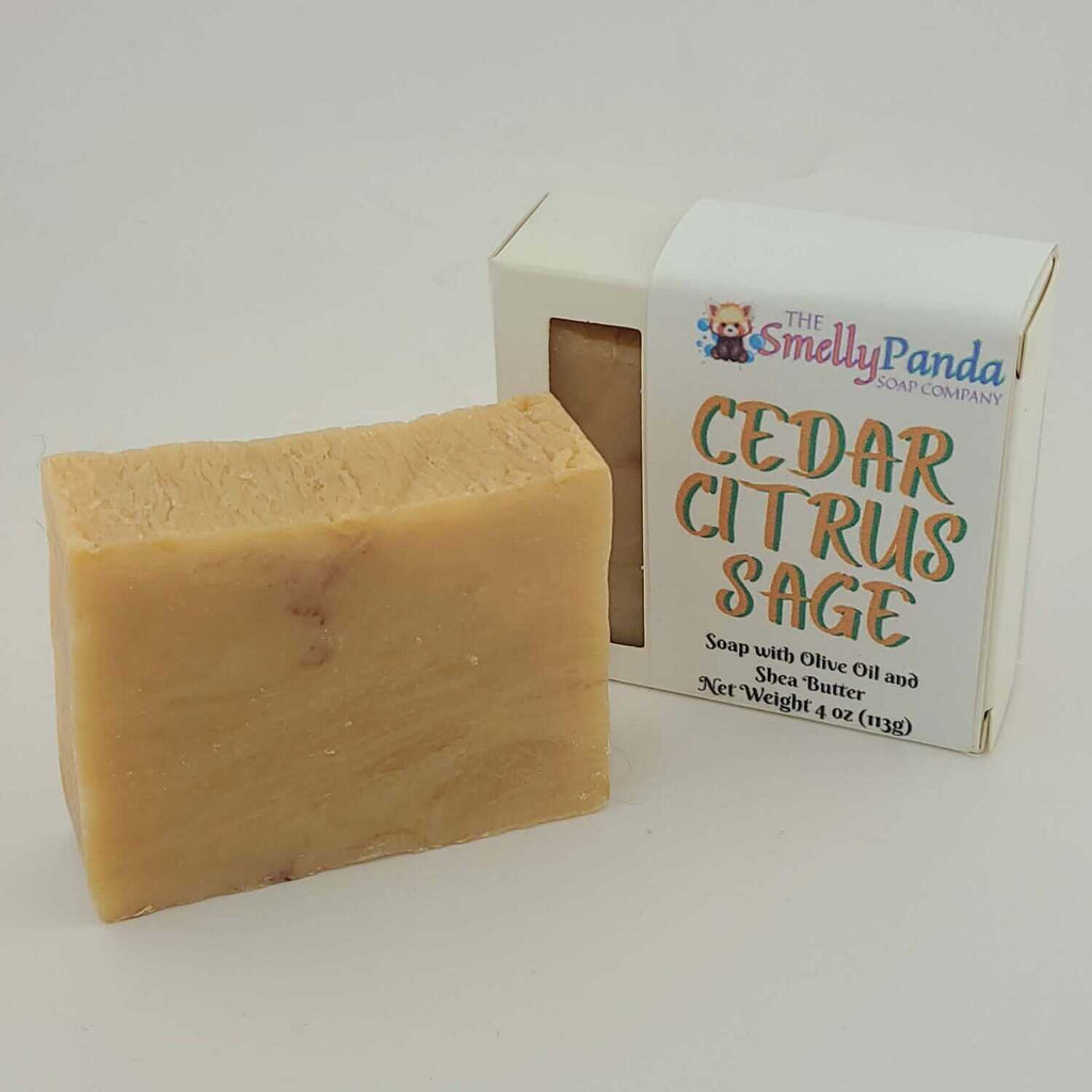 Bar of soap next to a box labeled 'Cedar Citrus Sage' by The Smelly Panda Soap Company on a white background.